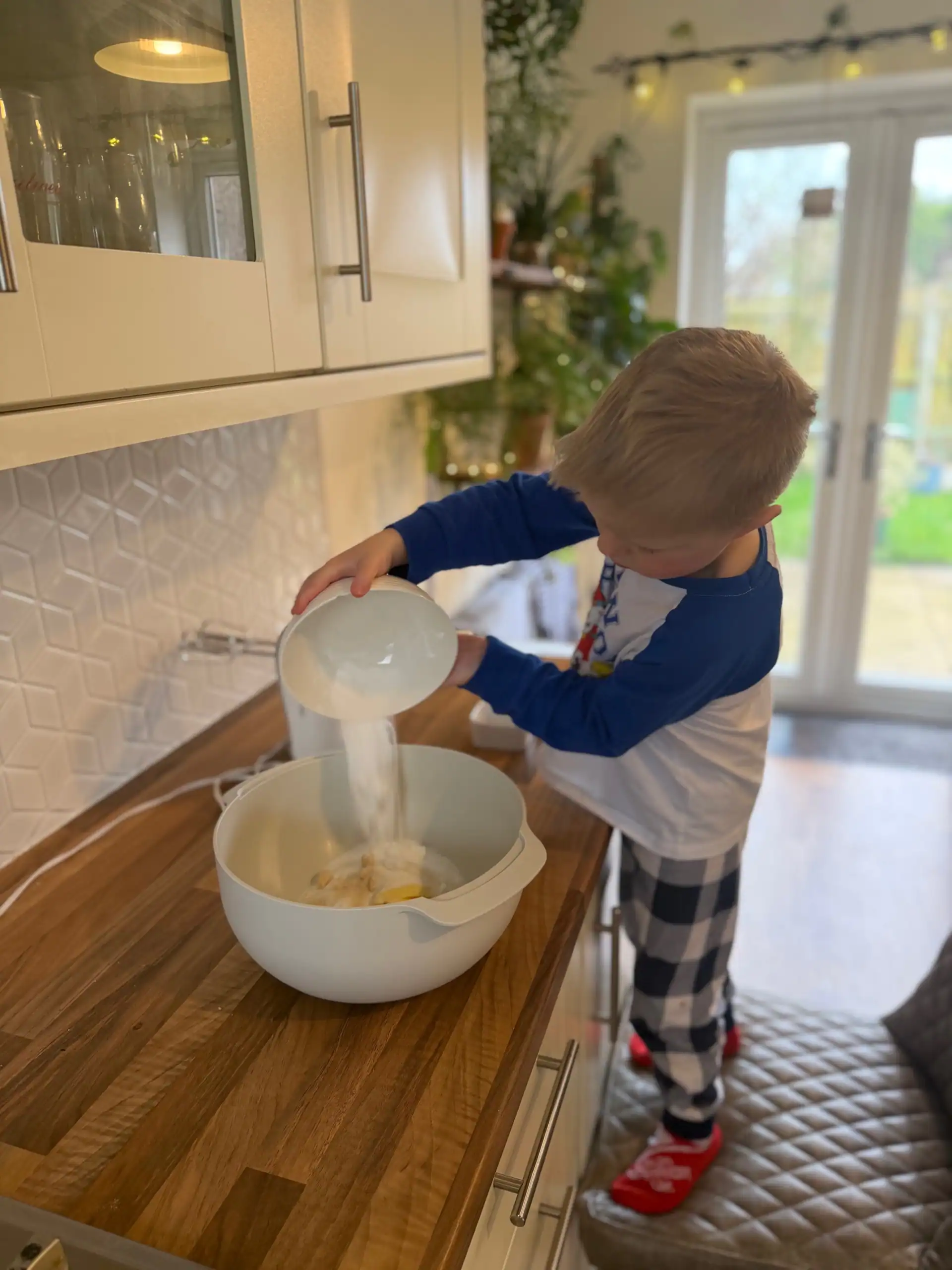 child adding dry ingredients