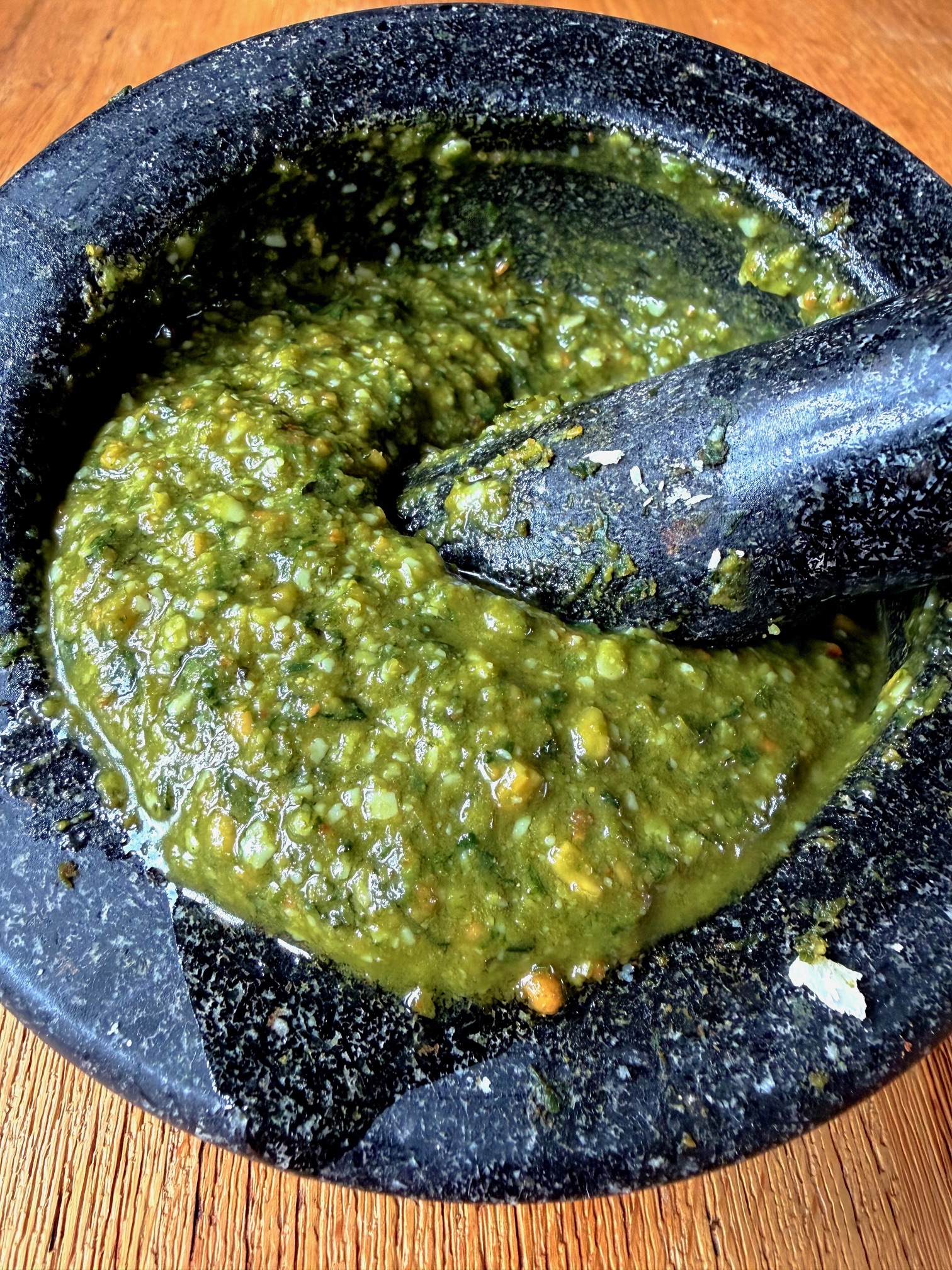 Homemade green pesto in a pestle and mortar