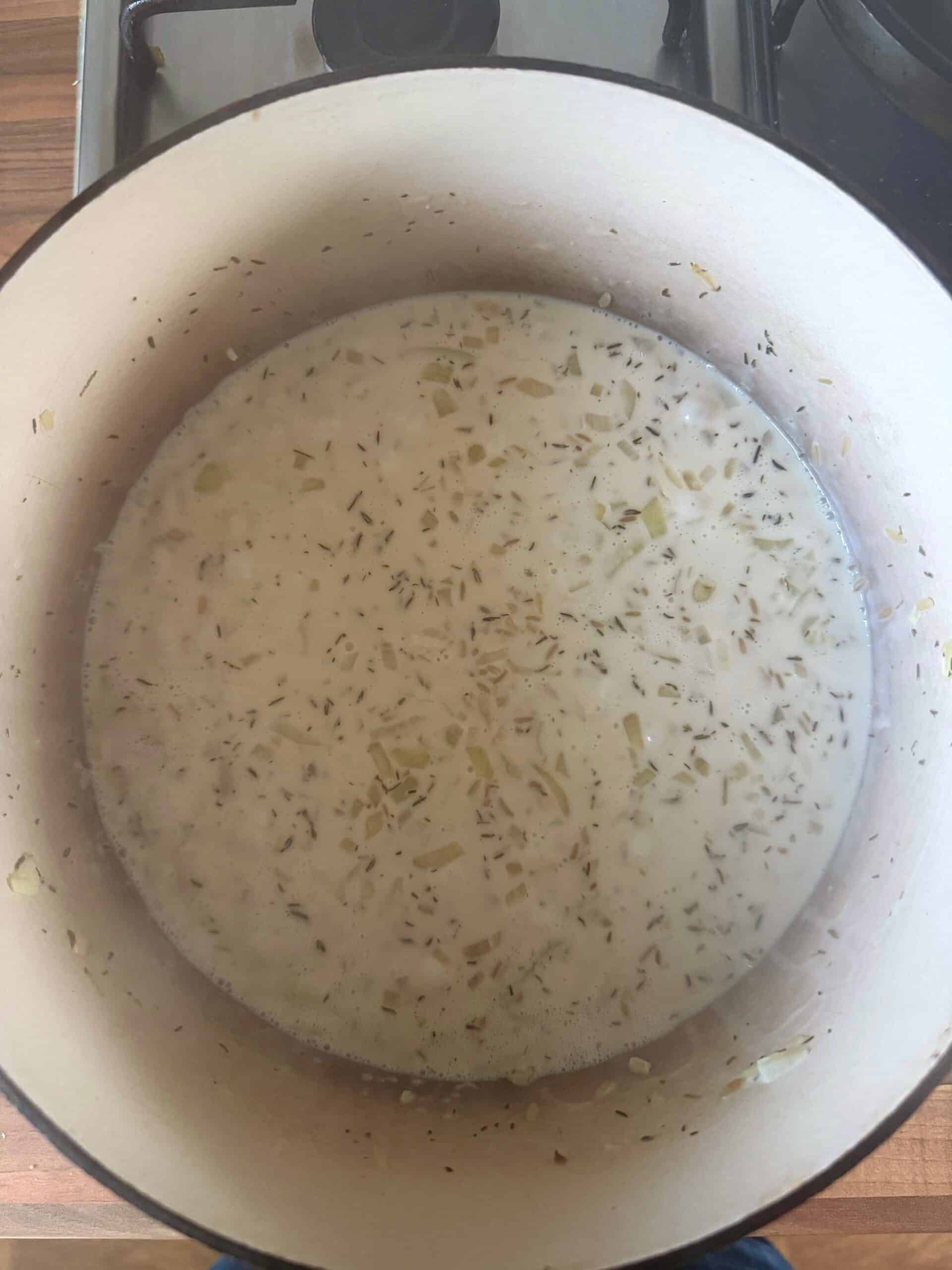 add in chicken stock to the pan of rice