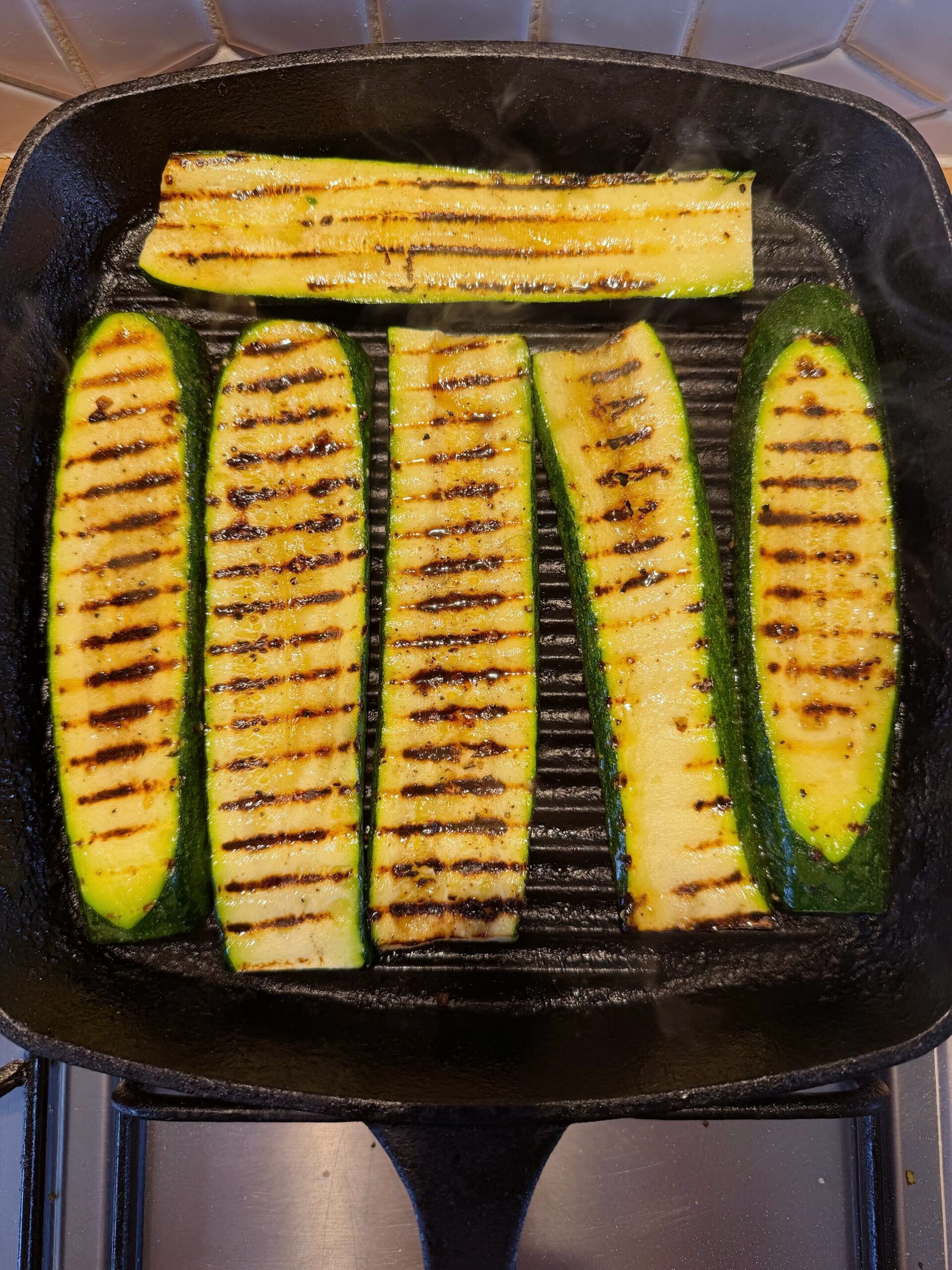 cooking courgette slices on a griddle pan
