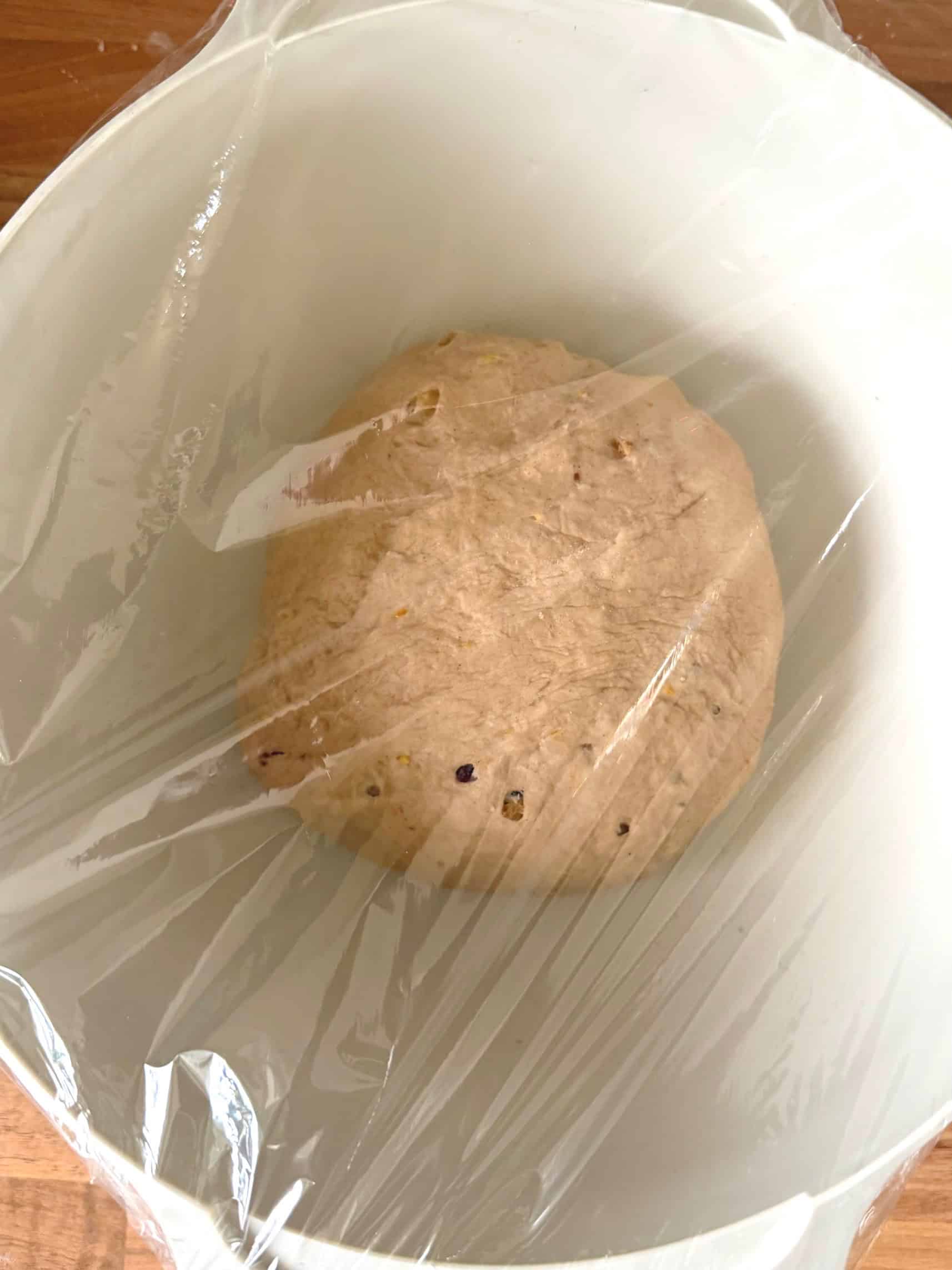 proving dough in a bowl covered in cling film
