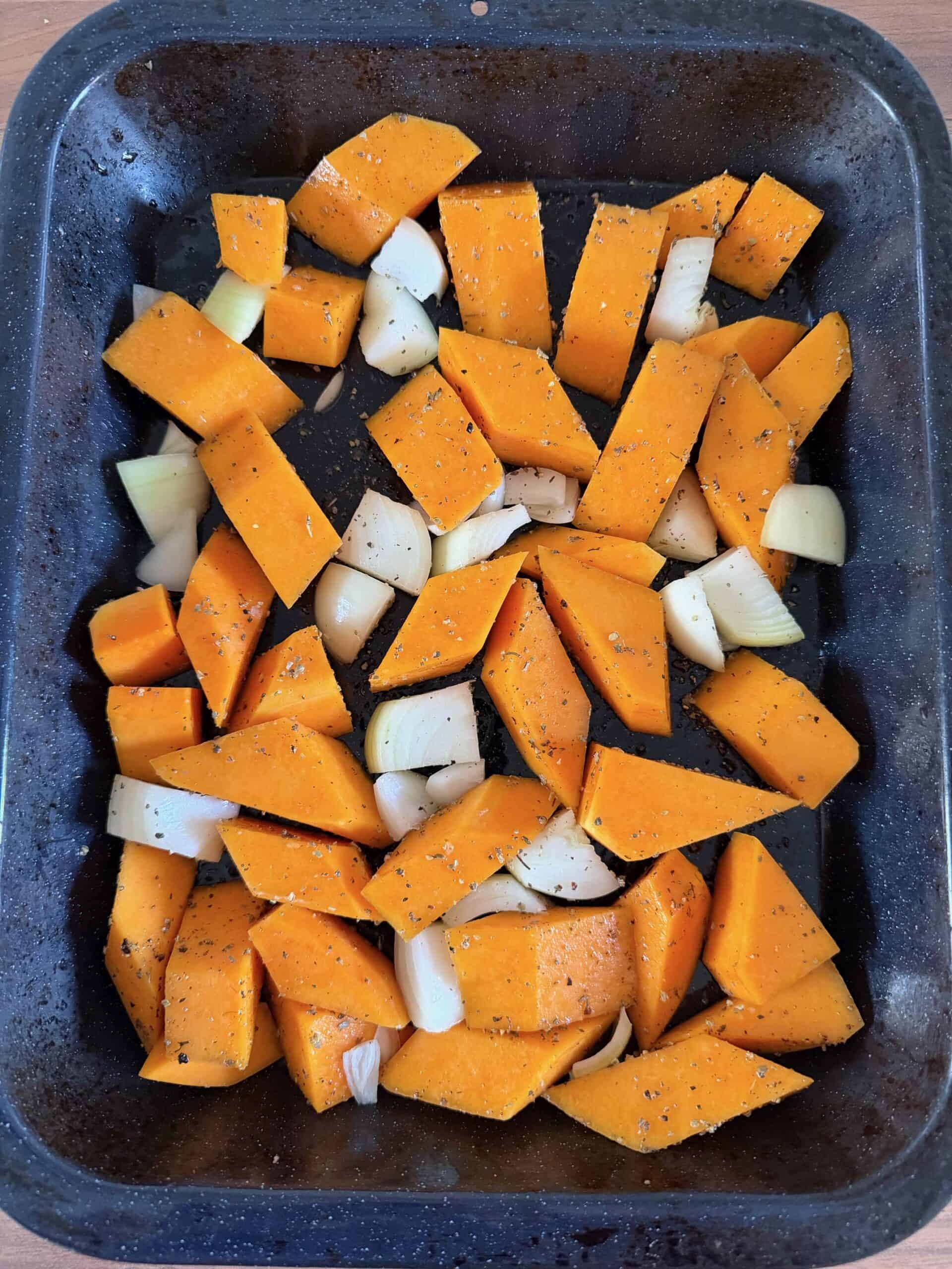 butternut squash and onions in a  tray ready for roasting