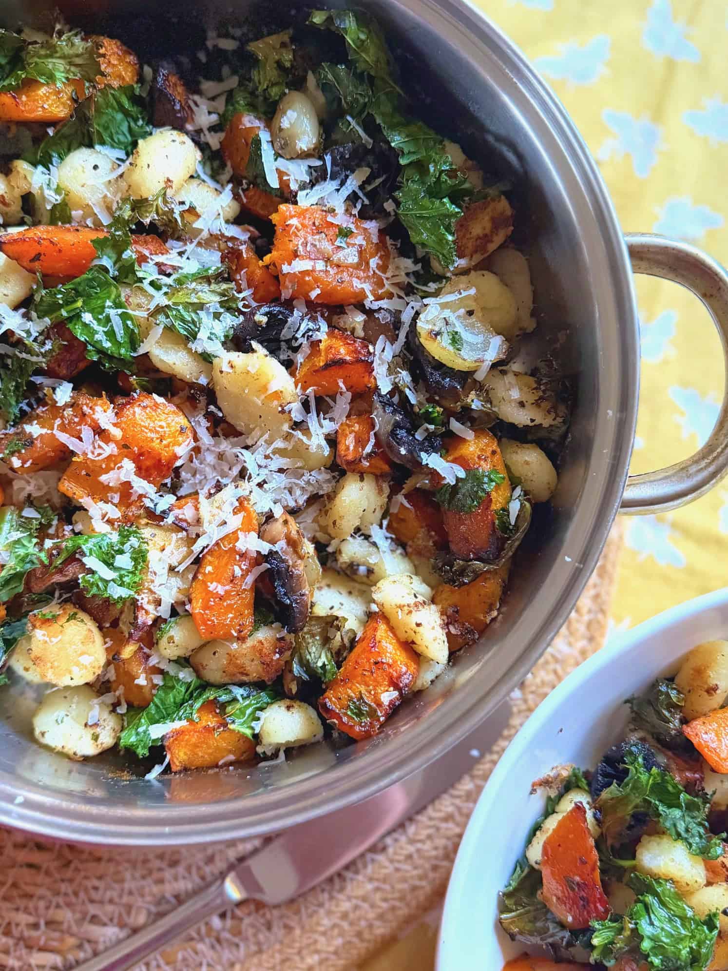 butternut squash gnocchi with truffle and parmesan in a pan with freshly grated parmesan