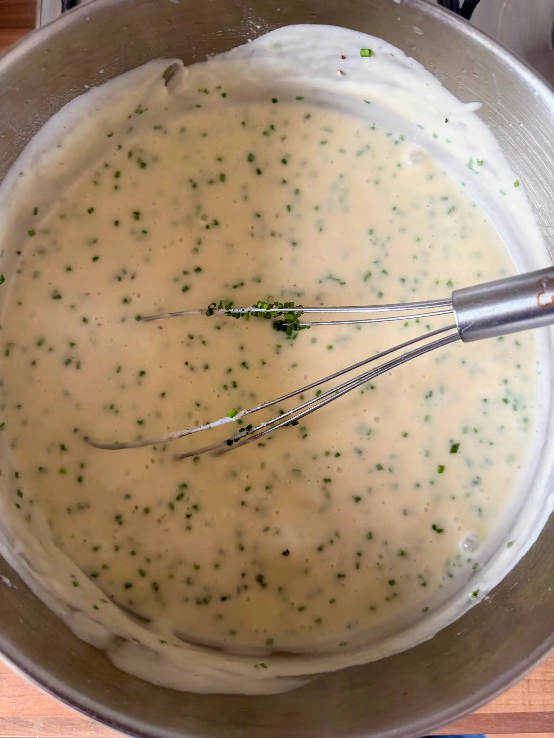 cheese sauce in a pan with a whisk