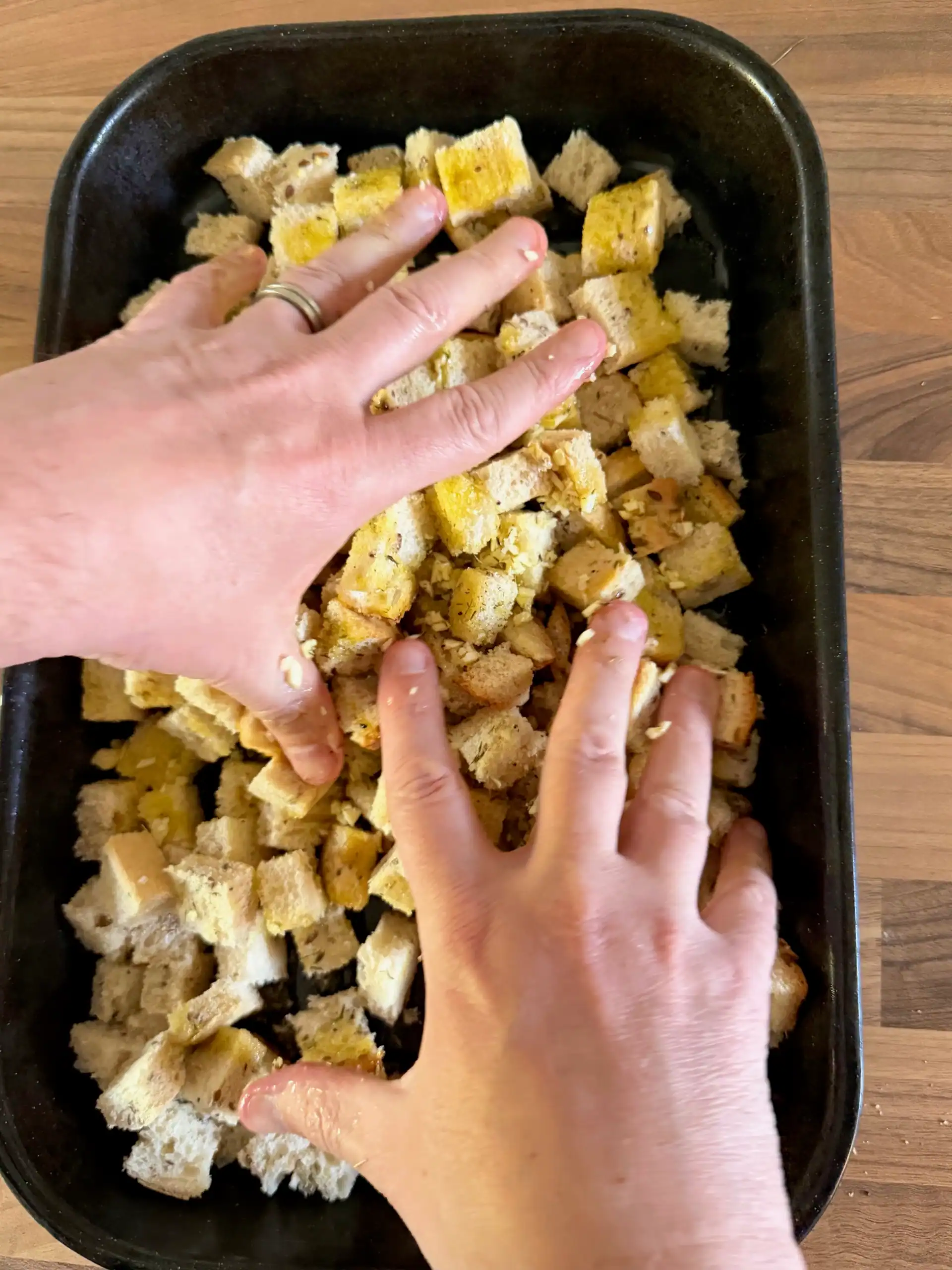 mixing croutons with hands