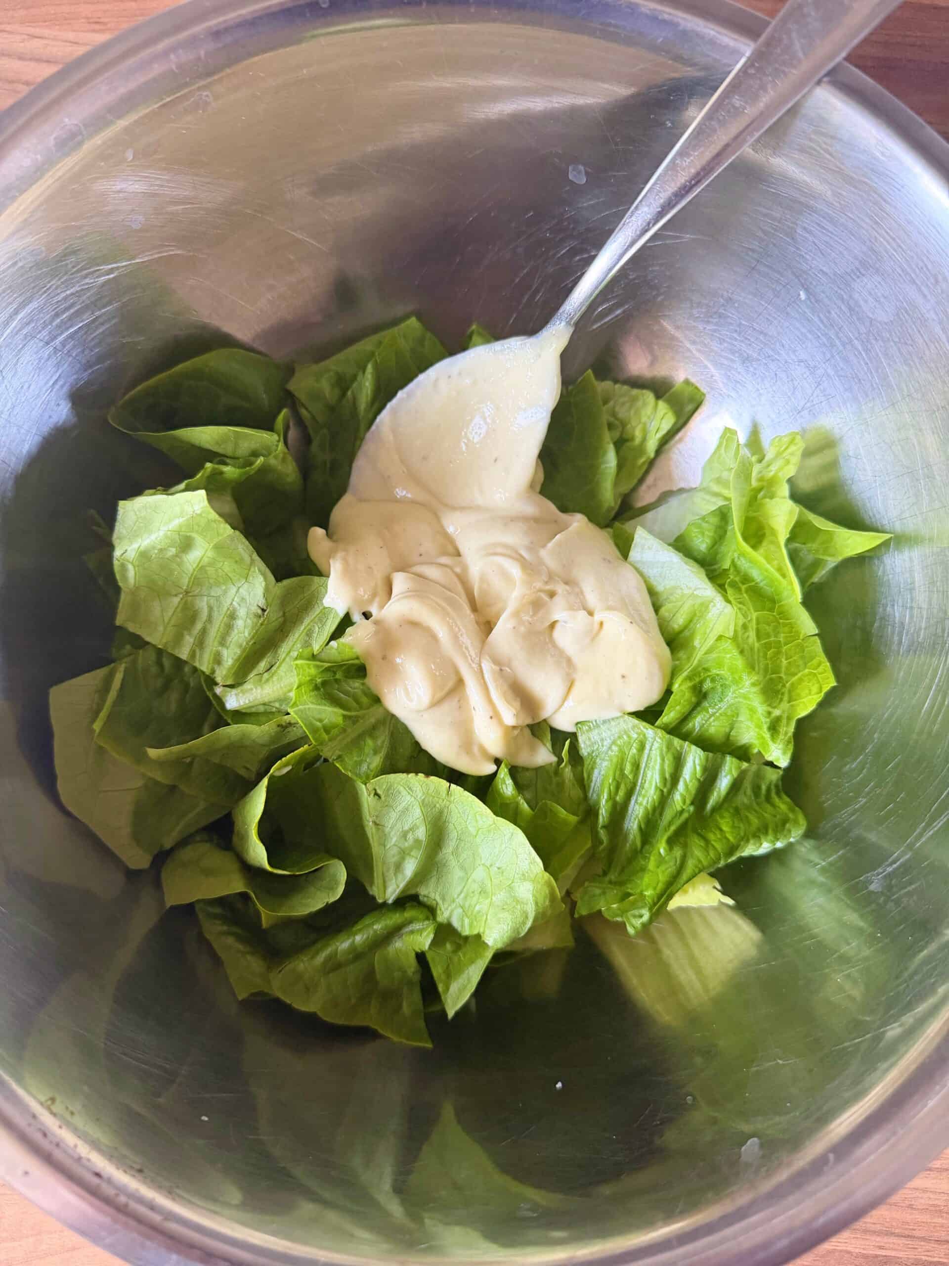 Mix caesar dressing with the leaves