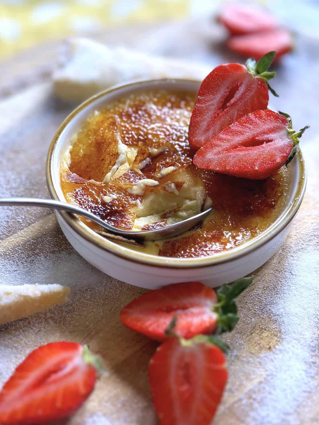 creme brulee with cracked sugar topping with red strawberries