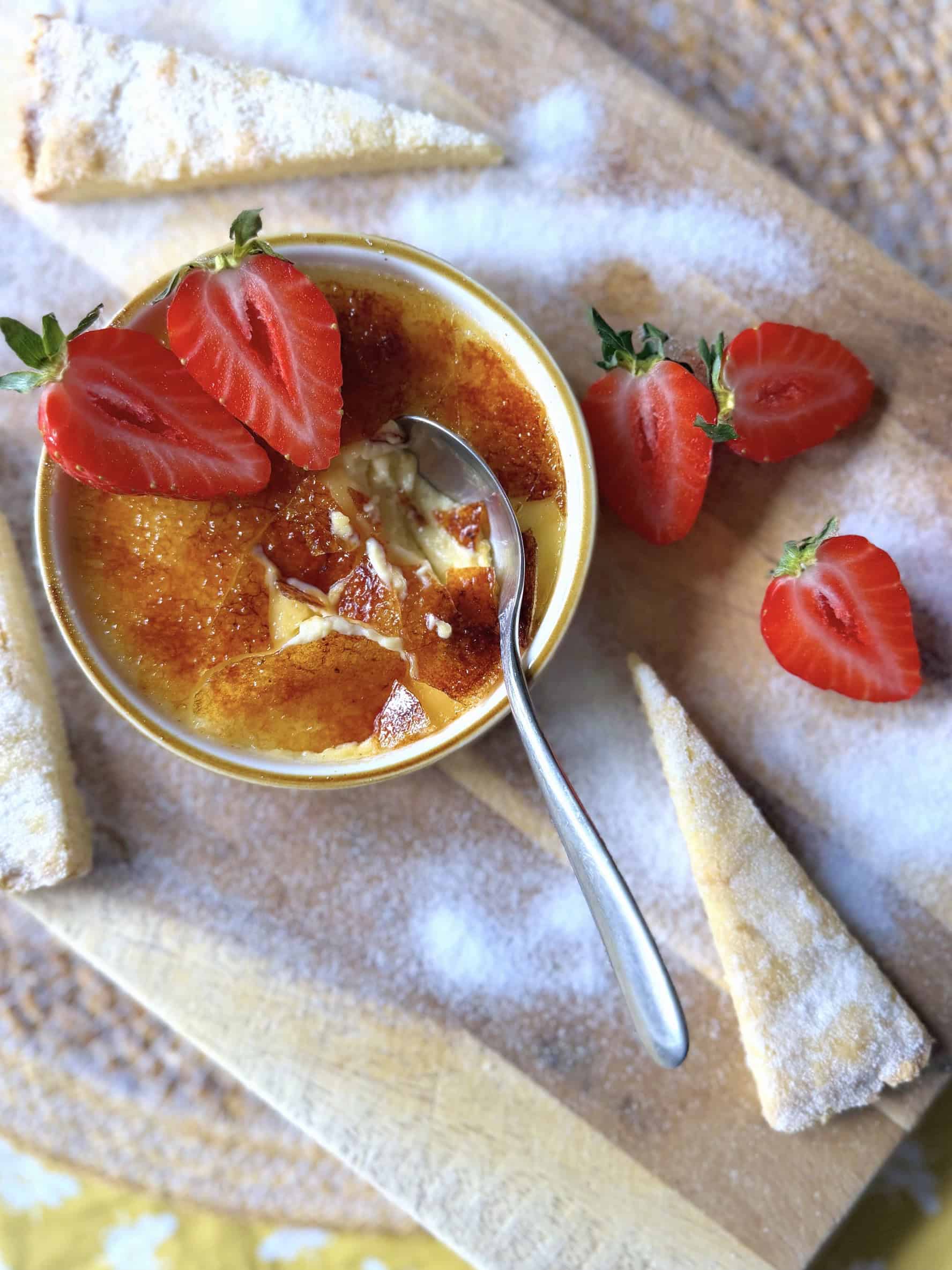 creme brulee with shortbread and strawberries and sugar