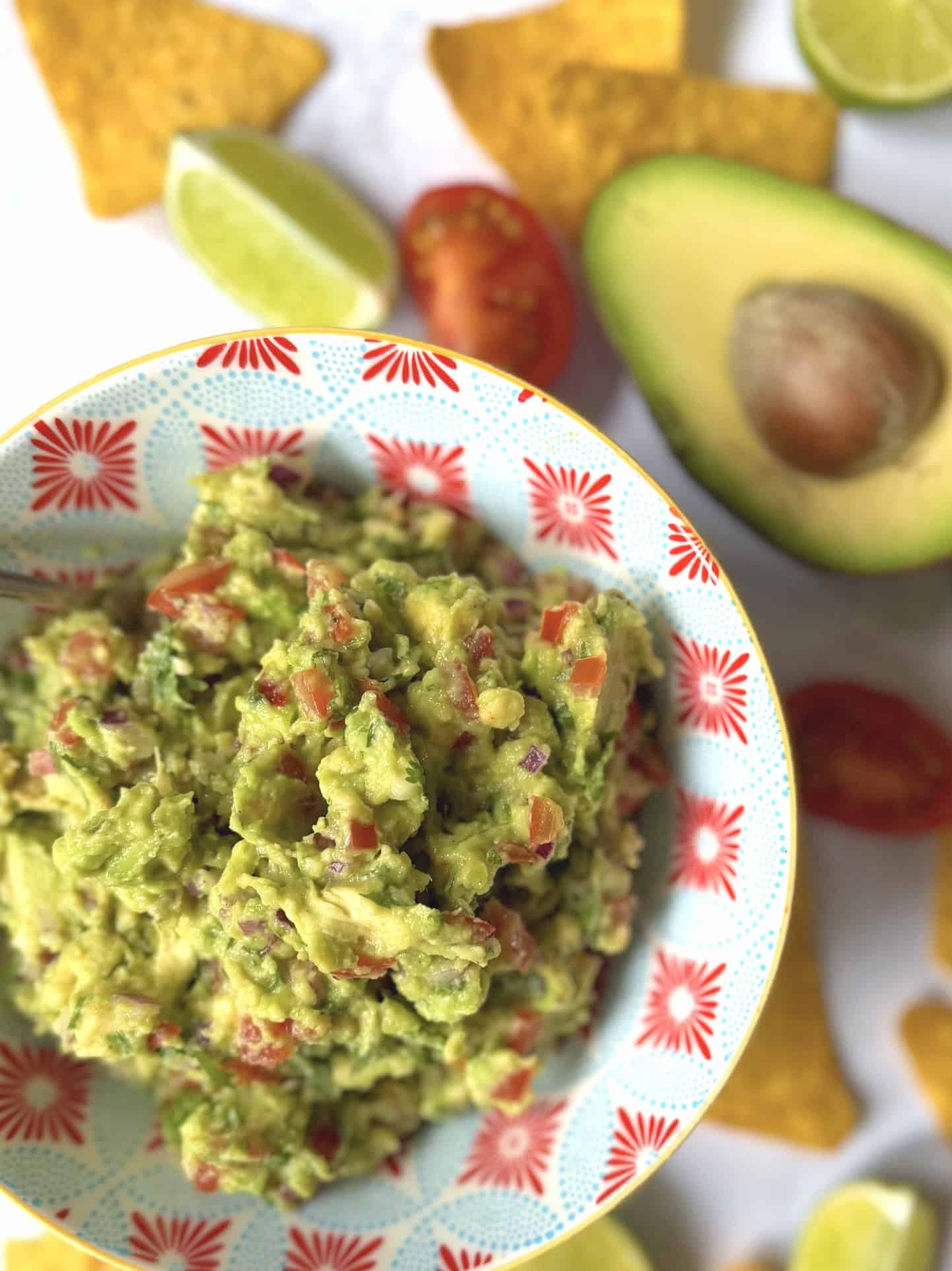 guacamole with avocado and lime  in background
