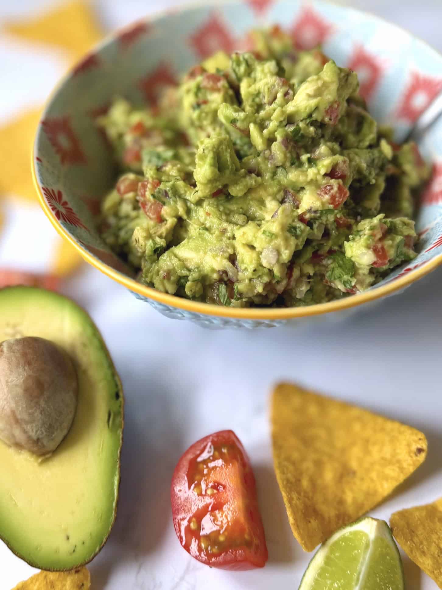 guacamole with avocado in background