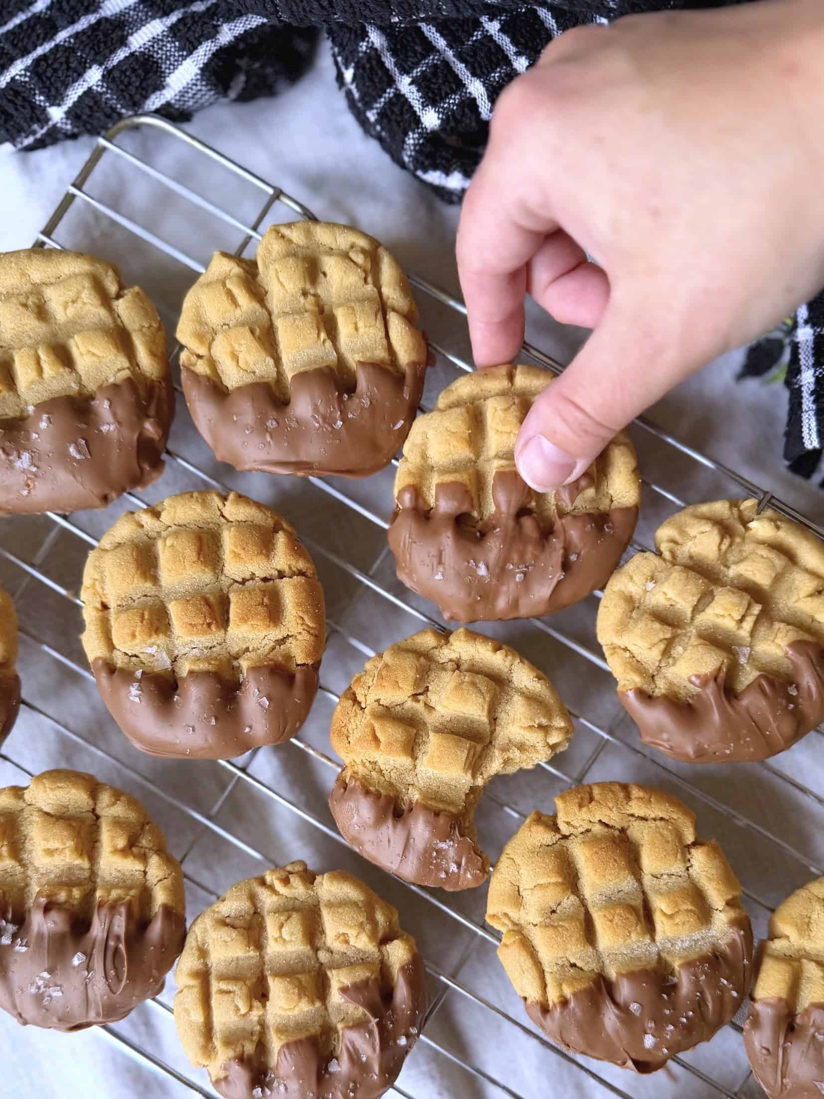 hand picking up a chocolate dipped peanut butter cookie