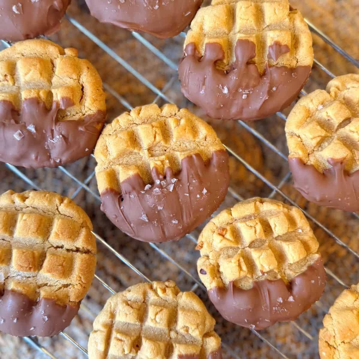 chocolate dipped peanut butter cookies on a cooling rack