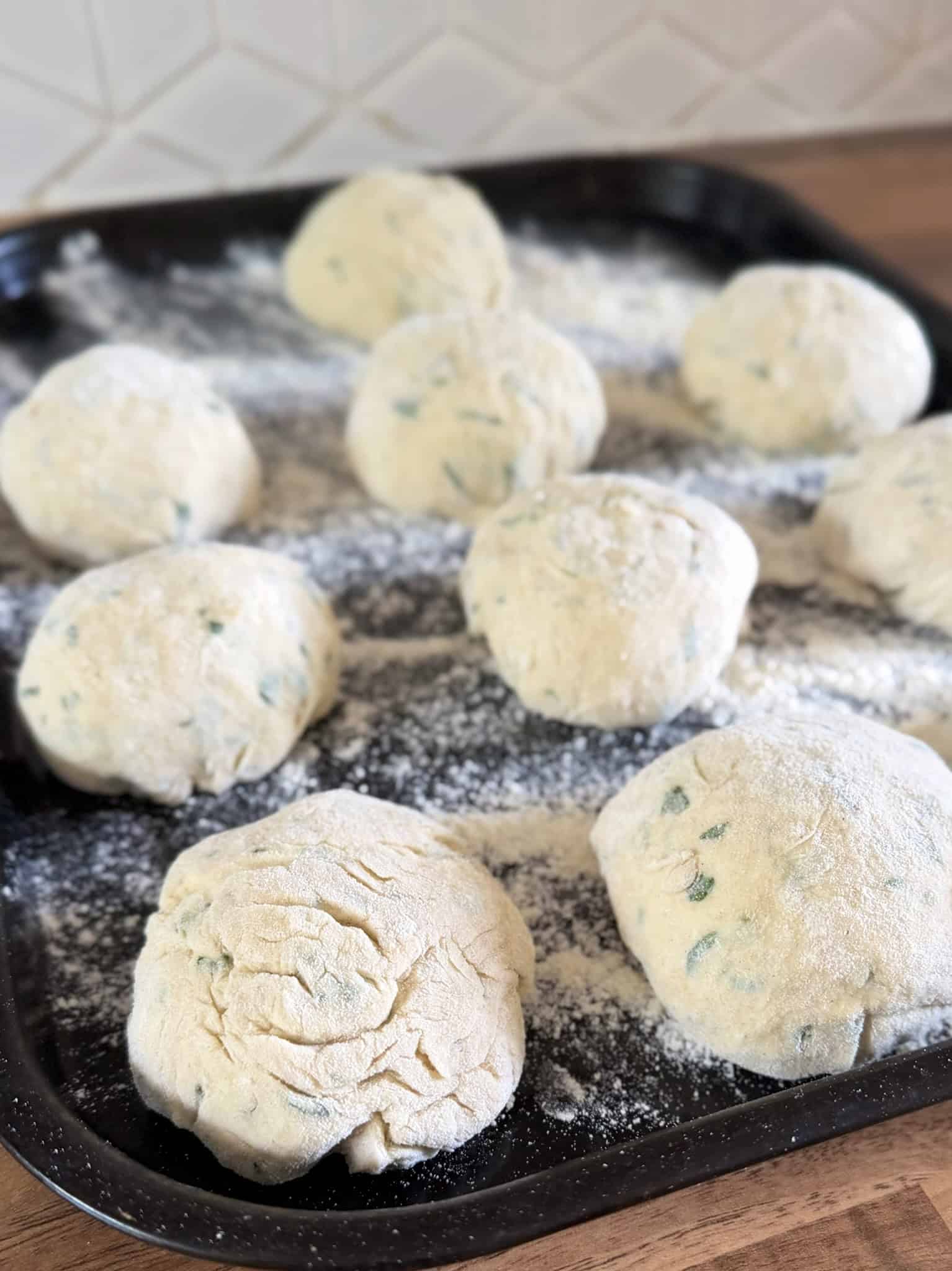 flatbread dough divided into 10 equal pieces on a tray