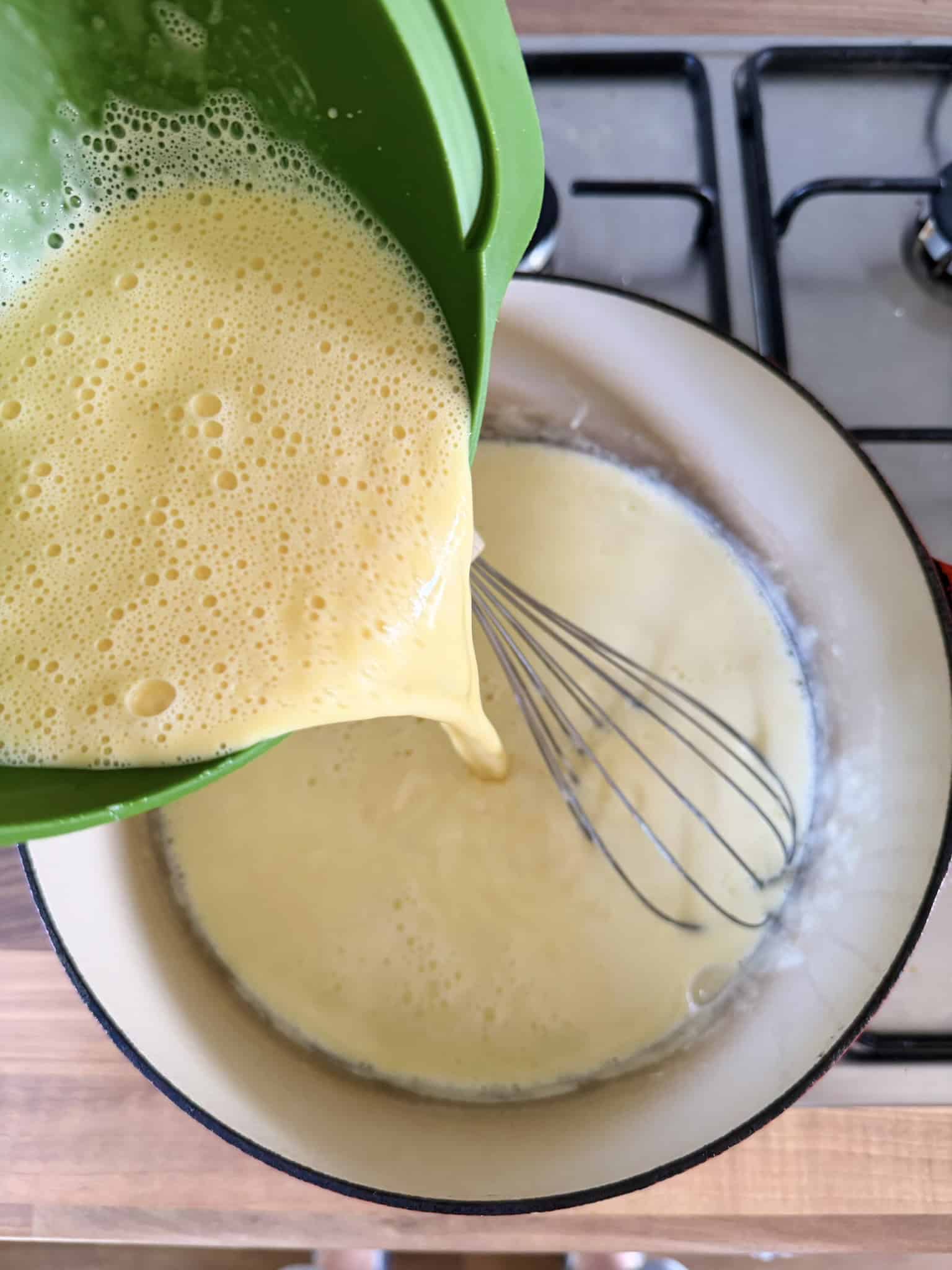 whisking tempered eggs into cream mixture