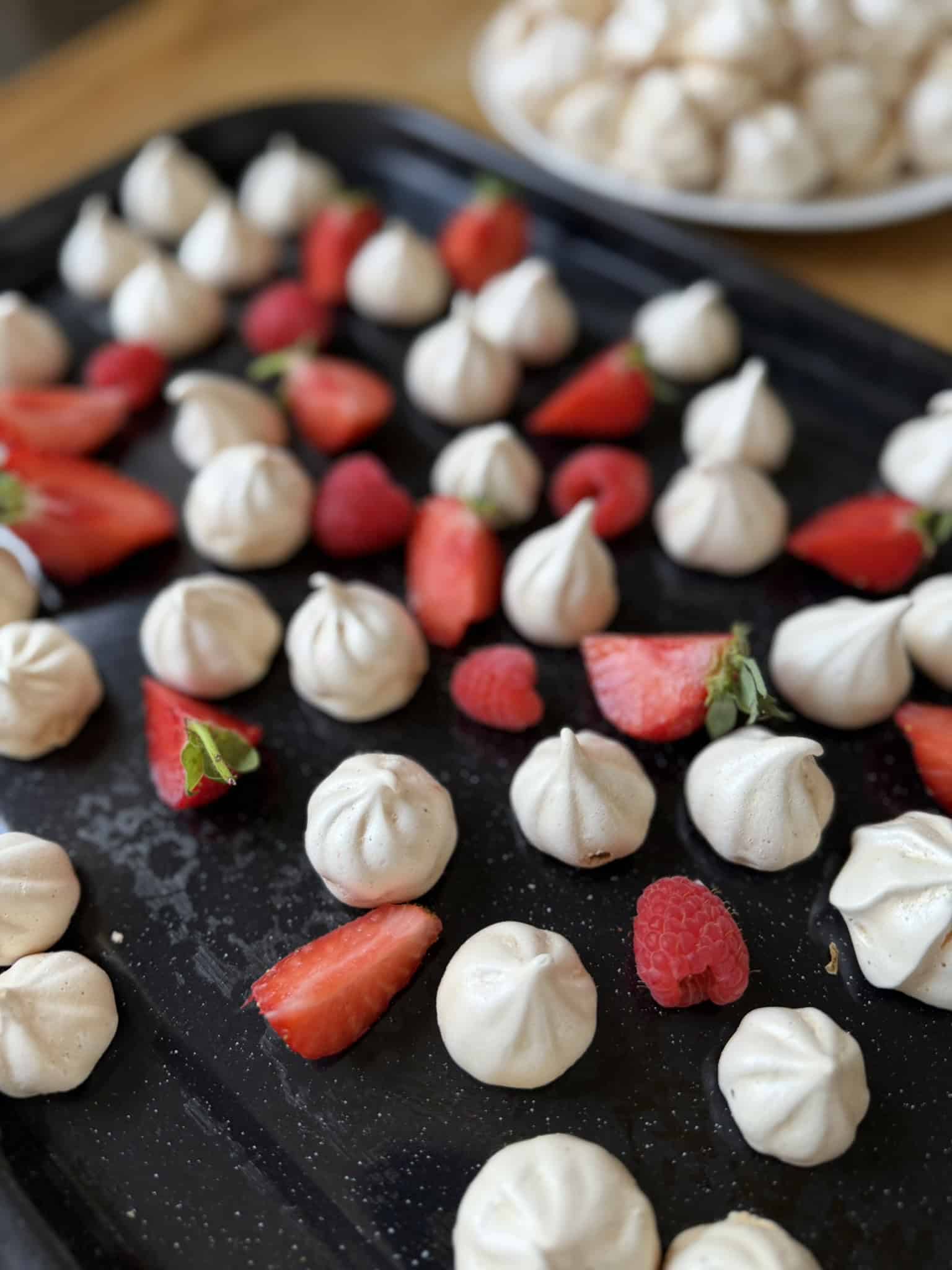 meringue kisses n black tray with red fruit