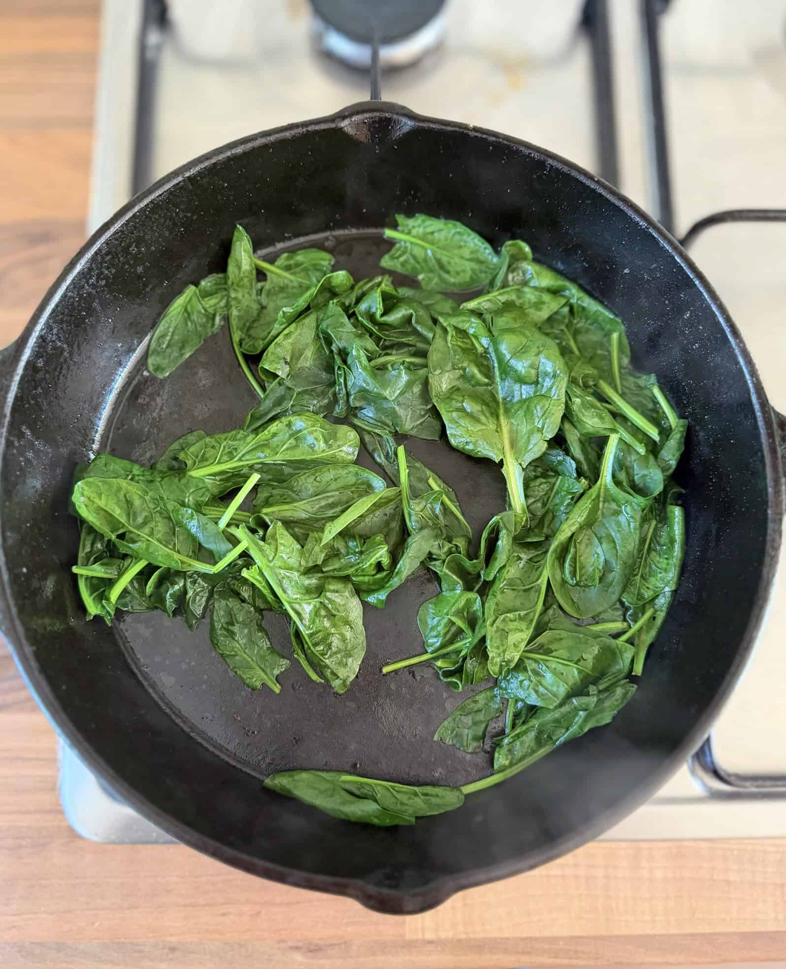 sautee spinach in a black skillet