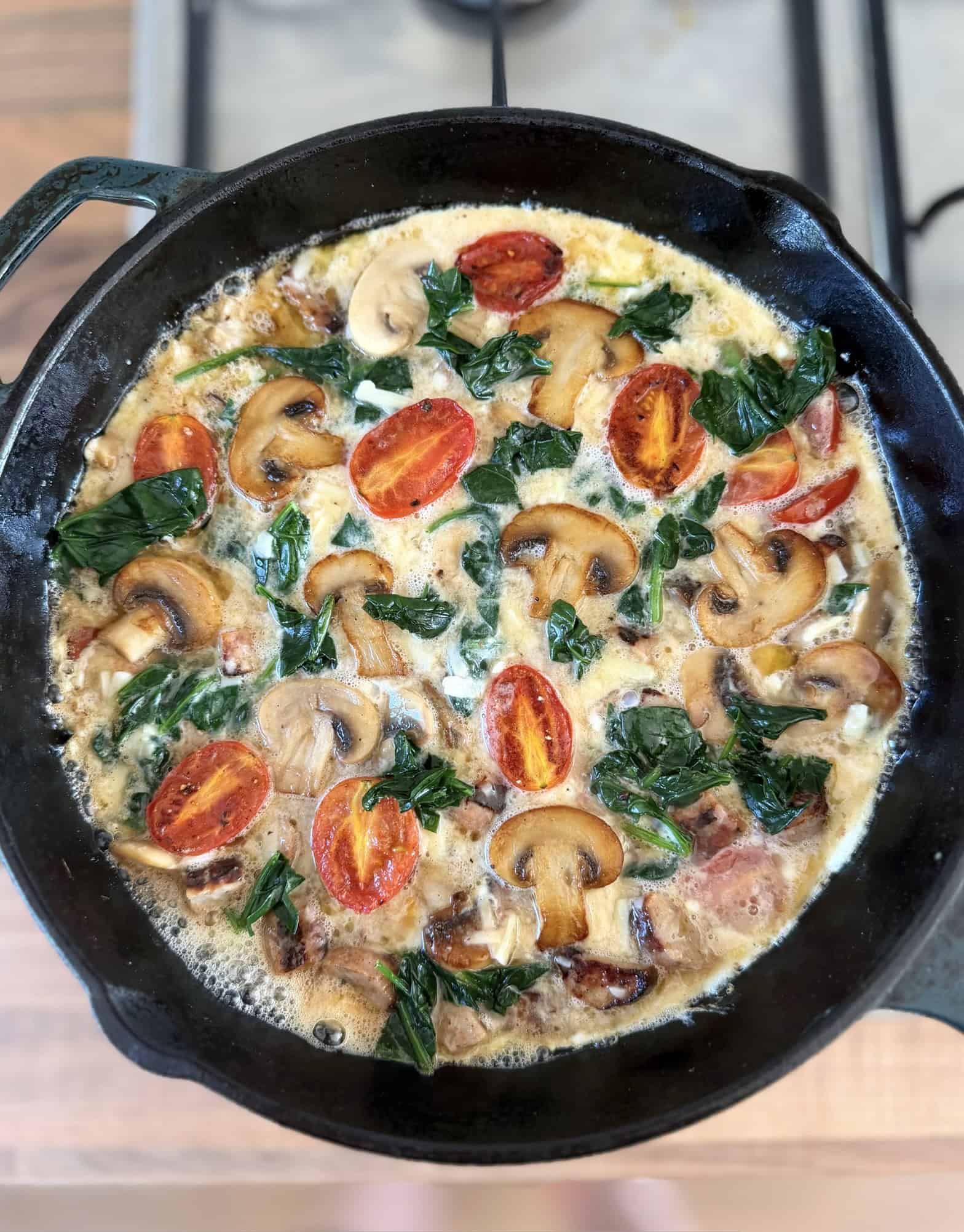 cooking frittata in black skillet on the hob