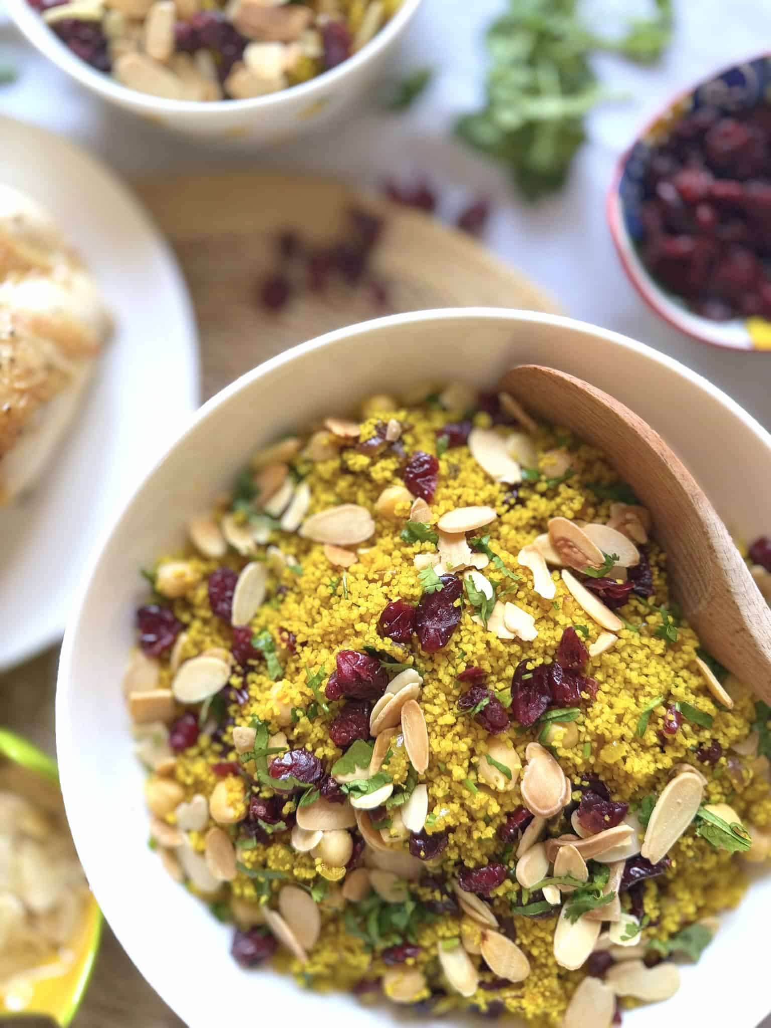 Moroccan couscous in a bowl with a wooden spoon