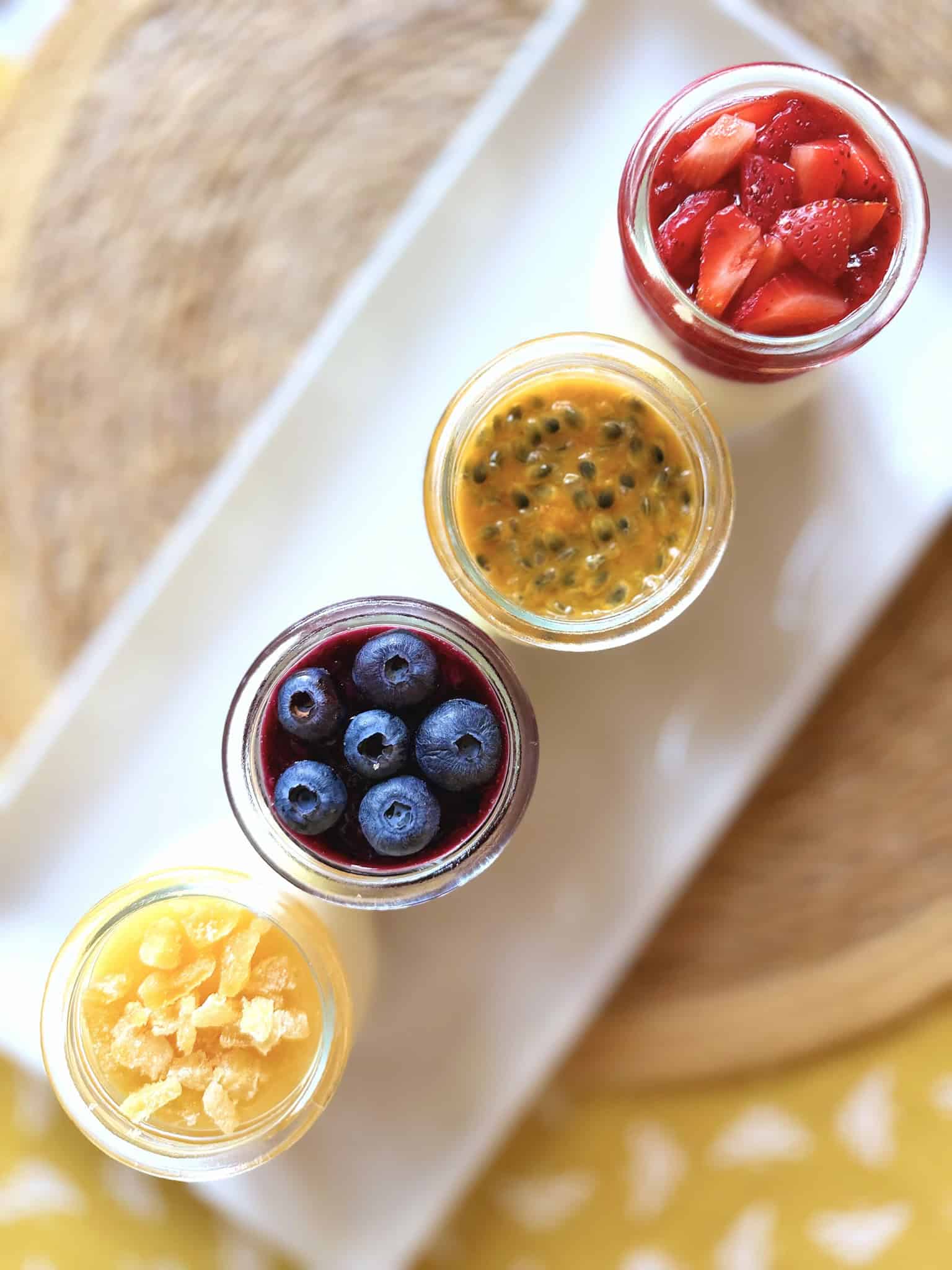 Blueberry, strawberry, lemon and passionfruit cheesecakes in small jars