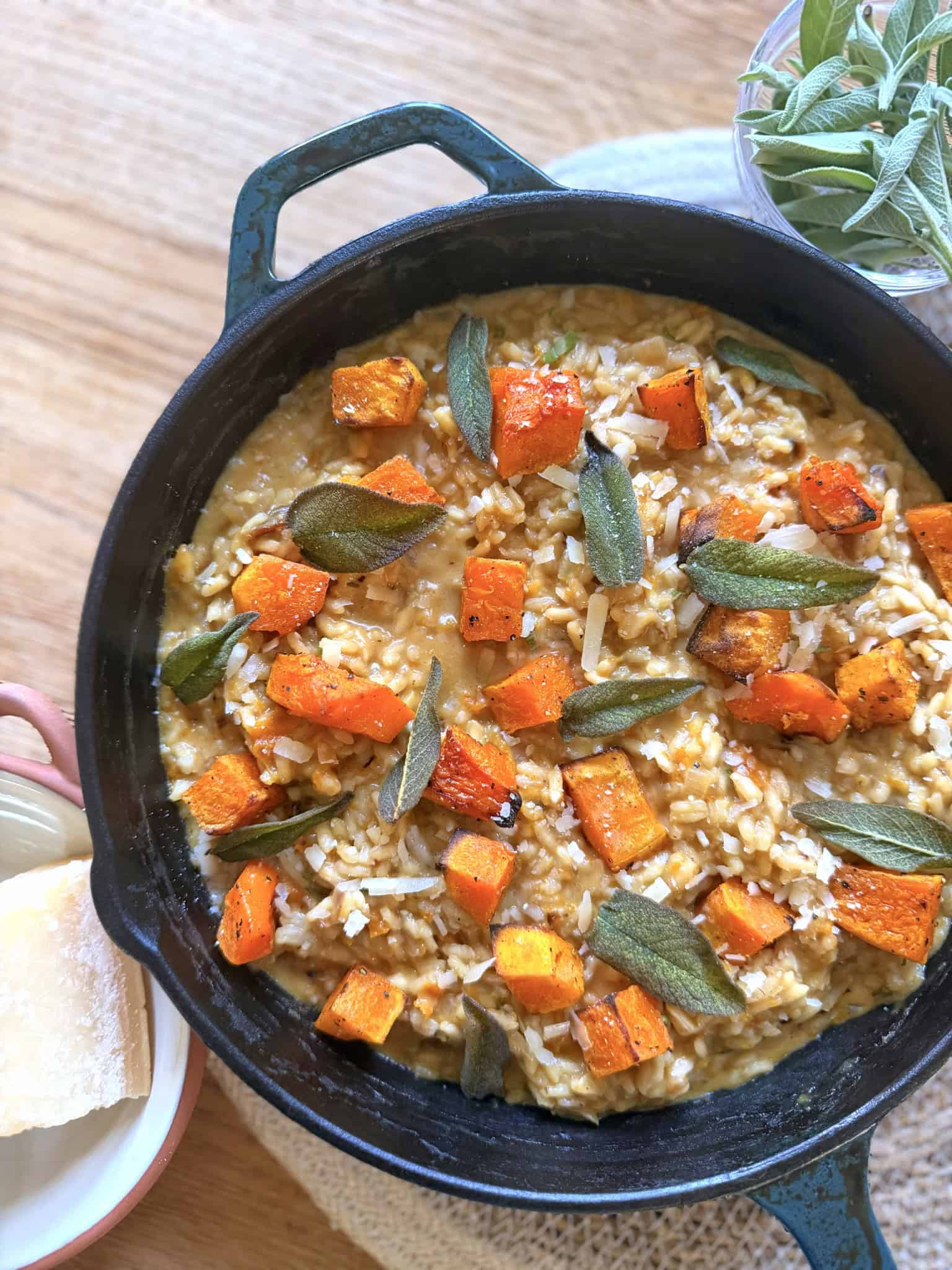 roast butternut squash risotto with sage and onion in a black cast iron skillet