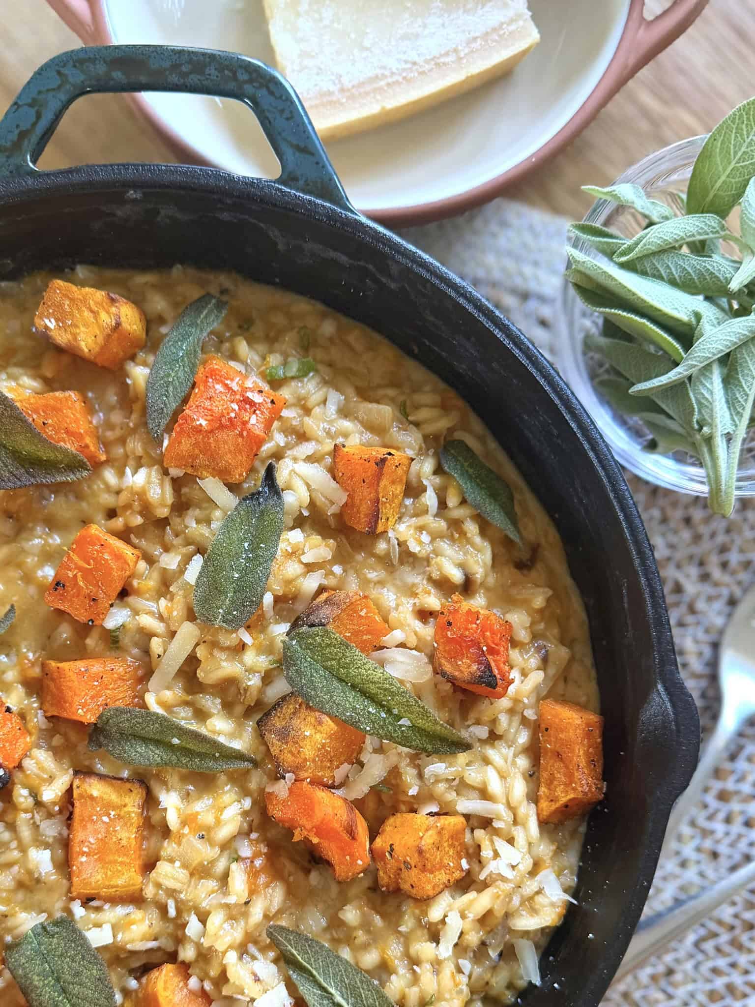 butternut squash and sage risotto with sage leaves in a black skillet