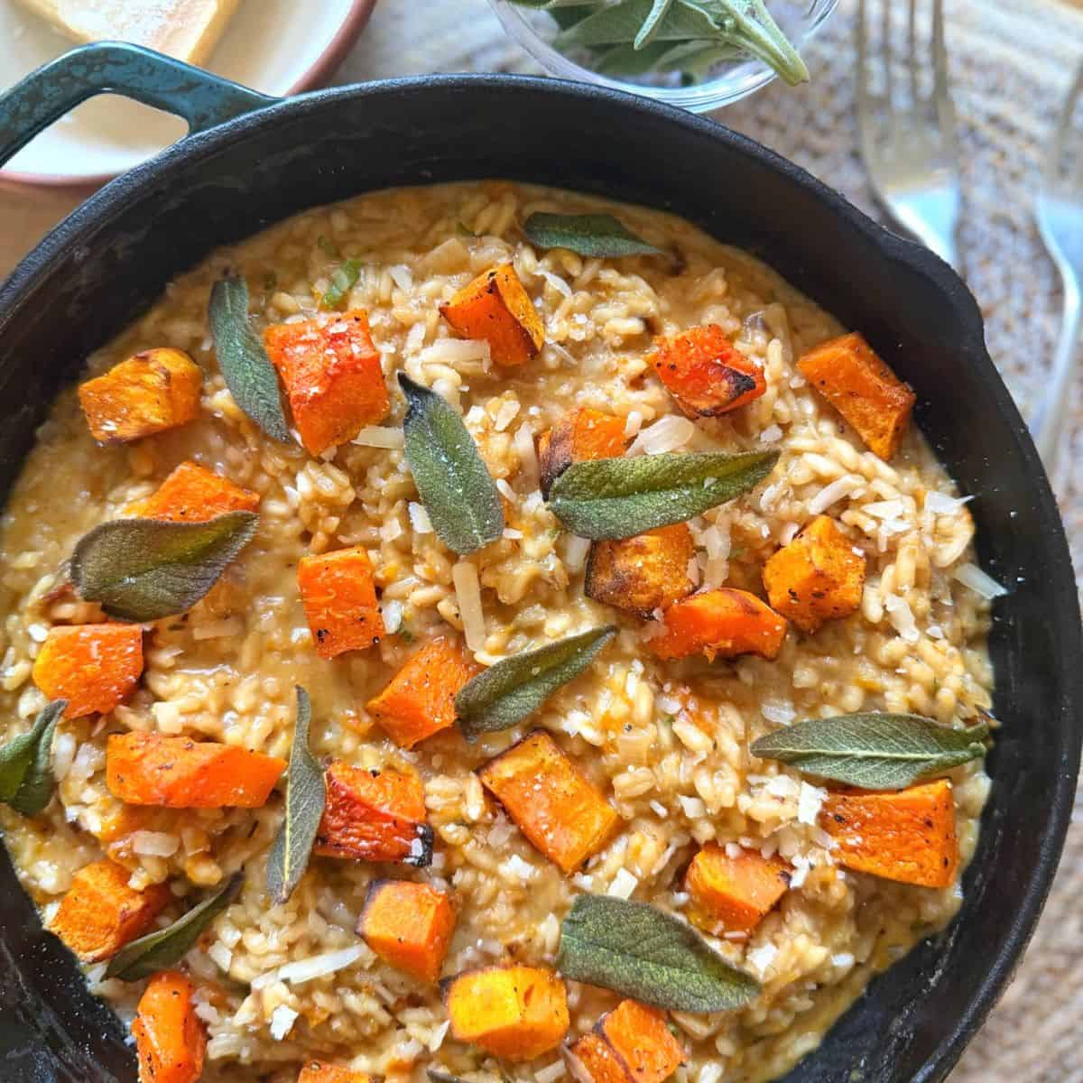 Butternut squash risotto with sage in a black skillet